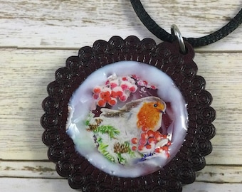 Christmas robin necklace--holiday necklace with 3D bird, greenery, and hand-painted snow in a wooden setting.