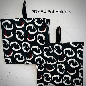 May include: Two black pot holders with a repeating pattern of white vampire fangs and red blood drops. Each pot holder has a black loop for hanging and the text "2DYE4 Pot Holders" is visible.