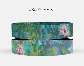 May include: Two rolls of colorful patterned handlebar tape with a floral design. The tape is blue, green, yellow, and pink with black dots. The text "Claus Monet" is written above the tape.