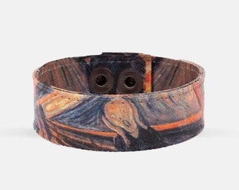 Op de afbeelding: Een bruin leren armband met een kleurrijke print van een beroemd schilderij. De armband heeft twee metalen drukknopen om de maat aan te passen.