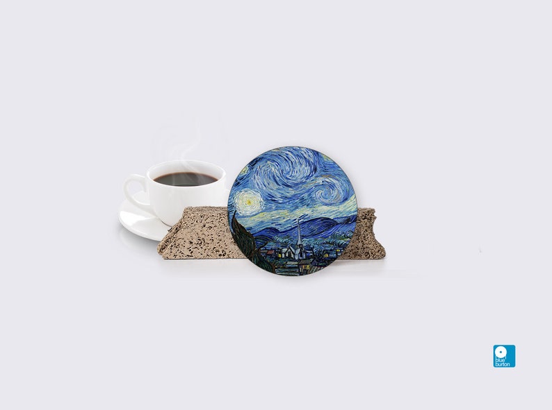 Puede incluir: Un posavasos redondo con una imagen azul y blanca de La noche estrellada de Van Gogh. El posavasos est&aacute; sobre una superficie marr&oacute;n texturizada.