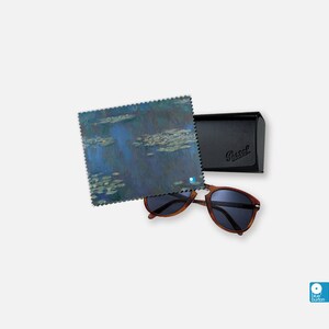 May include: A pair of brown tortoiseshell sunglasses with dark lenses, a black case with the word "Persol" embossed on it, and a blue and white microfiber cleaning cloth with a painting of water lilies.