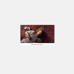 May include: A man lies on a red and gold patterned rug. He is wearing a light brown shirt and dark pants. The text "I really find the room together." is below the image.