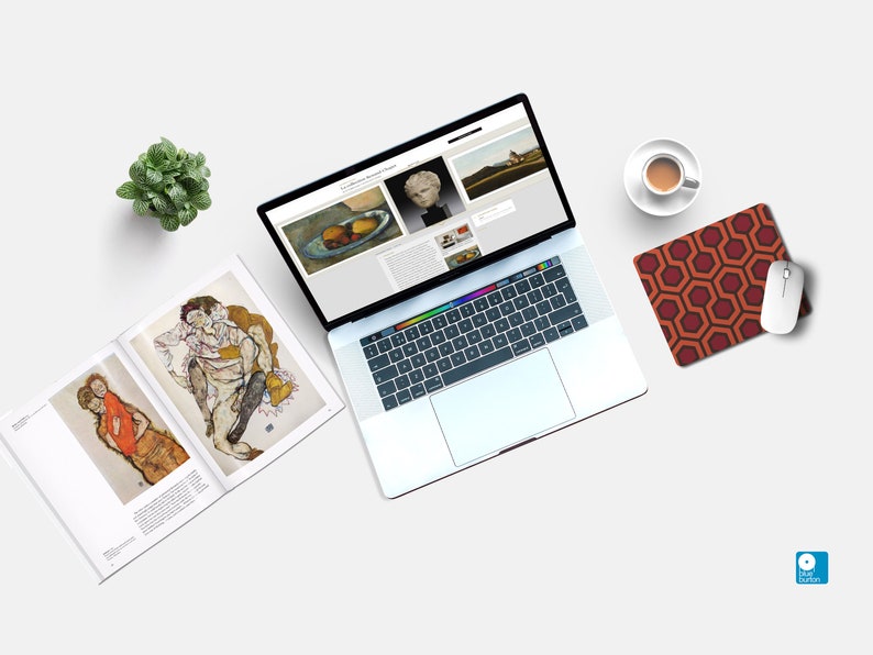 Pu&ograve; includere: Un computer portatile con uno sfondo bianco e un tappetino per mouse con un motivo geometrico. Il laptop &egrave; aperto e mostra un sito web con immagini d'arte. Ci sono due libri con immagini d'arte sul lato sinistro del laptop. Una piccola pianta in vaso si trova nell'angolo in alto a sinistra dell'immagine. Una tazza di caff&egrave; si trova nell'angolo in alto a destra dell'immagine.