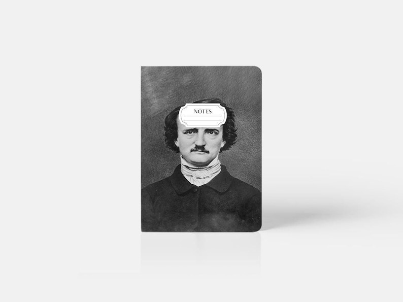 May include: A black and white photo of Edgar Allan Poe on a dark gray notebook cover. The notebook cover has a white label with the word "NOTES" printed on it.
