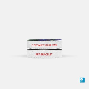 May include: Two white art bracelets stacked. The top bracelet has the text "CUSTOMIZE YOUR OWN" in red. The bottom bracelet has the text "ART BRACELET" in red. The top of the top bracelet has a colorful floral design.