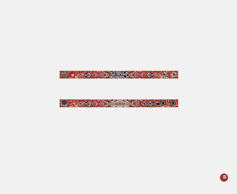 May include: Two red, white, and blue patterned fabric wristbands with silver metal clasps. The top wristband has the text "It really tied the room together" and the bottom wristband has the text "The Dude abides".
