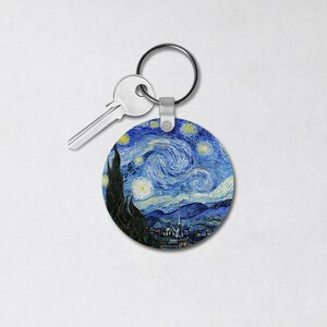 May include: A round keychain featuring a reproduction of Vincent van Gogh's "The Starry Night" painting. The keychain is attached to a silver key ring.