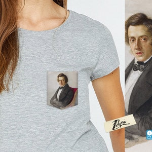May include: A gray t-shirt with a pocket featuring a portrait of a man in a black suit and white shirt with a bow tie. The man is sitting in a red chair. The t-shirt has a small blue button on the bottom right corner.