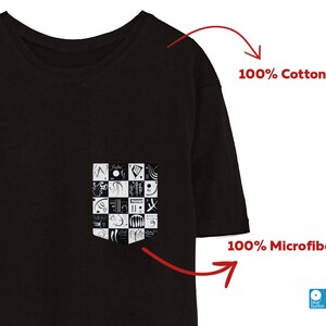 May include: Black t-shirt with a pocket featuring a black and white graphic design. The t-shirt is made of 100% cotton.