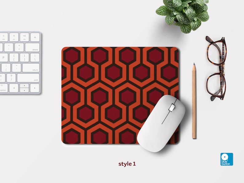 Pu&ograve; includere: Un tappetino per mouse con un motivo geometrico rosso e arancione con un mouse bianco sopra. Il tappetino per mouse ha un motivo esagonale ripetitivo. Il testo "style 1" &egrave; sotto il tappetino per mouse.