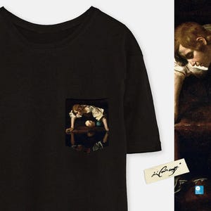 Pode incluir: Camiseta preta com um bolso que apresenta uma pintura de um menino olhando para um charco de &aacute;gua. A pintura &eacute; de Caravaggio e a assinatura &eacute; vis&iacute;vel no bolso.