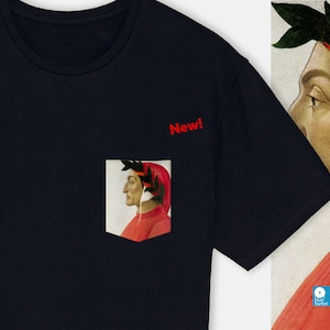 May include: A navy blue t-shirt with a pocket featuring a portrait of a man with a laurel wreath and red clothing. The text "New!" is printed on the shirt.