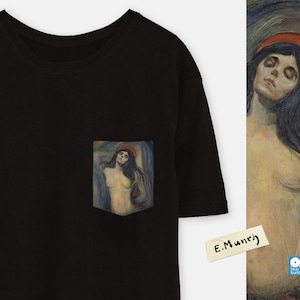 May include: Black t-shirt with a pocket featuring a painting of a woman with long dark hair and a red headband. The painting is titled "E. Munch".