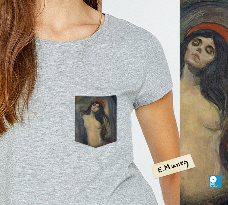 May include: A grey t-shirt with a pocket featuring a painting of a woman with long dark hair and a red hat. The painting is titled "E. Munch".