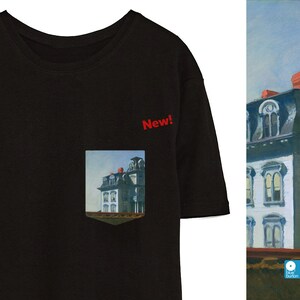 Peut inclure: T-shirt noir avec une poche repr&eacute;sentant une peinture d'une maison. La poche porte l'inscription "New!" au-dessus.