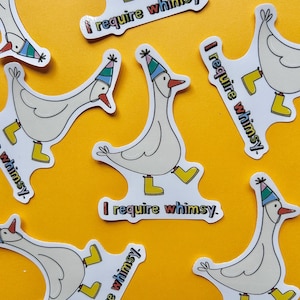 May include: A collection of whimsical stickers featuring a cartoon goose wearing a party hat and yellow boots. Each sticker has the text "I require whimsy" in colorful letters. The stickers are on a yellow background.