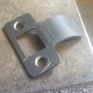Vintage inspired T steel strike plate, laser cut with hand forged extended curved lip to protect door jamb millwork countersunk screw holes.