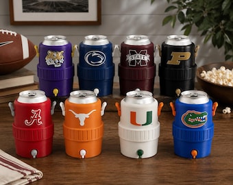 May include: Eight small, cylindrical beverage coolers shaped like soda cans, each featuring a different collegiate sports logo. The coolers are arranged in two rows and come in various colours including purple, blue, maroon, black, red, orange, white, and blue.