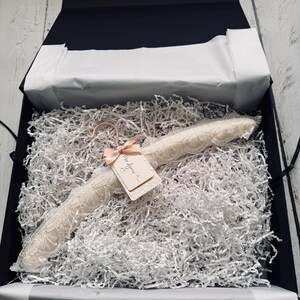 Op de afbeelding: Een gevoerde kledinghanger bekleed met cr&egrave;mekleurig kant, voorzien van een ros&eacute;gouden haak en een klein rechthoekig label vastgemaakt met een perzikkleurig lint. Op het label staat de handgeschreven tekst Mrs Lyons met een hartje eronder.
