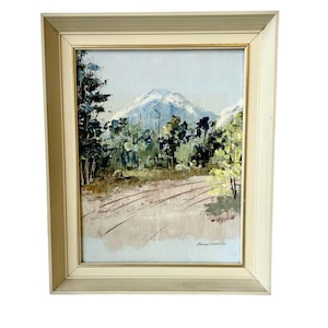 May include: Framed oil painting depicting a mountain landscape with a dirt road winding through a forest of trees. The sky is a pale blue and the mountain is snow-capped. The painting is signed "Robin Sorenson" in the bottom right corner.
