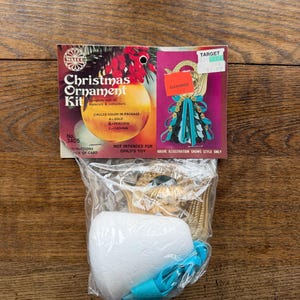 May include: A vintage Christmas ornament kit in a clear plastic bag, with a cardboard package featuring a gold ornament illustration. The package includes instructions and is marked "Clearance" with a Target price tag.
