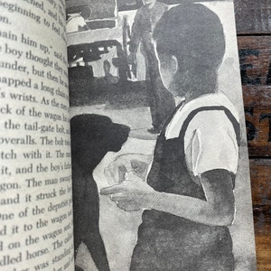 May include: A black and white illustration of a boy holding a dog. The boy is wearing a white shirt and dark pants. The dog is looking at the boy. In the background, there are three men standing near a wagon.