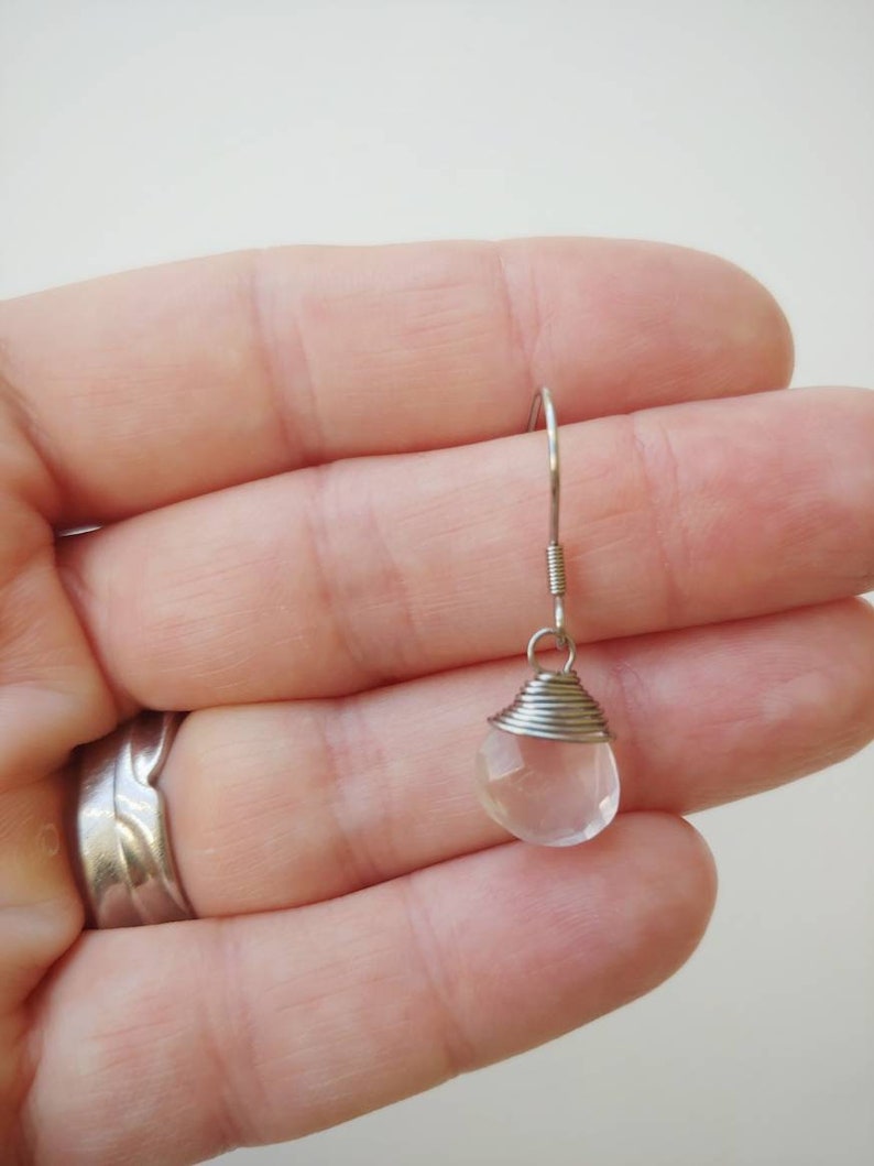 May include: A silver wire wrapped clear quartz crystal dangle earring.