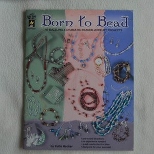 May include: A book cover titled "Born to Bead" featuring various beaded jewelry projects. The cover displays necklaces, bracelets, and earrings in different colors and designs. The book promises 67 dazzling and dramatic projects with pre-tested directions.