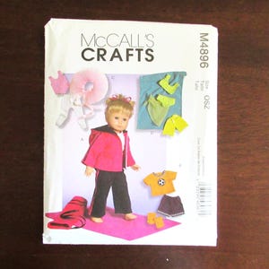 May include: McCall's Crafts sewing pattern for a doll, pattern number M4896, size OSZ. The pattern includes instructions for making a pink jacket, black pants, a yellow and black soccer jersey, a black and white skirt, and a pair of orange socks.