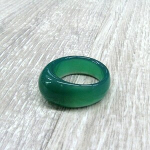 May include: A green agate ring with a smooth, polished finish.