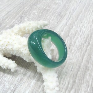 May include: A green jade ring with a smooth, polished finish. The ring is thick and has a rounded shape.