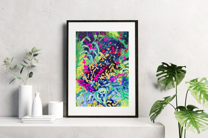 May include: Abstract painting of a colourful floral design with pink, blue, green, and yellow hues. The painting is framed in a black frame.