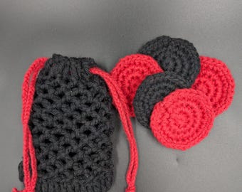 May include: A black crocheted drawstring pouch with a lattice pattern and red cord ties, accompanied by a set of five circular crocheted pads in alternating black and red colors, arranged in a cluster next to the pouch.