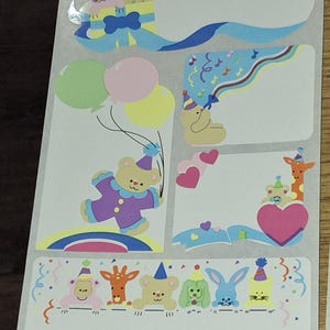 Puede incluir: Hoja de pegatinas coloridas con temática de fiesta. Los diseños incluyen osos de peluche, conejos y jirafas con sombreros de fiesta, globos, corazones y notas musicales. Las pegatinas tienen espacios en blanco para escribir.