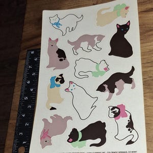 May include: A sheet of vintage cat stickers featuring various cat illustrations in different colors and poses. The stickers include cats with bows and collars. The text at the bottom reads "CURRENT CATS JUMBO STICKER PACK ©1984 CURRENT, INC., COLORADO SPRINGS, CO 80941."