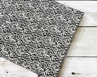 May include: Black and white fabric with a damask pattern. The fabric has a white background with a black intricate design.