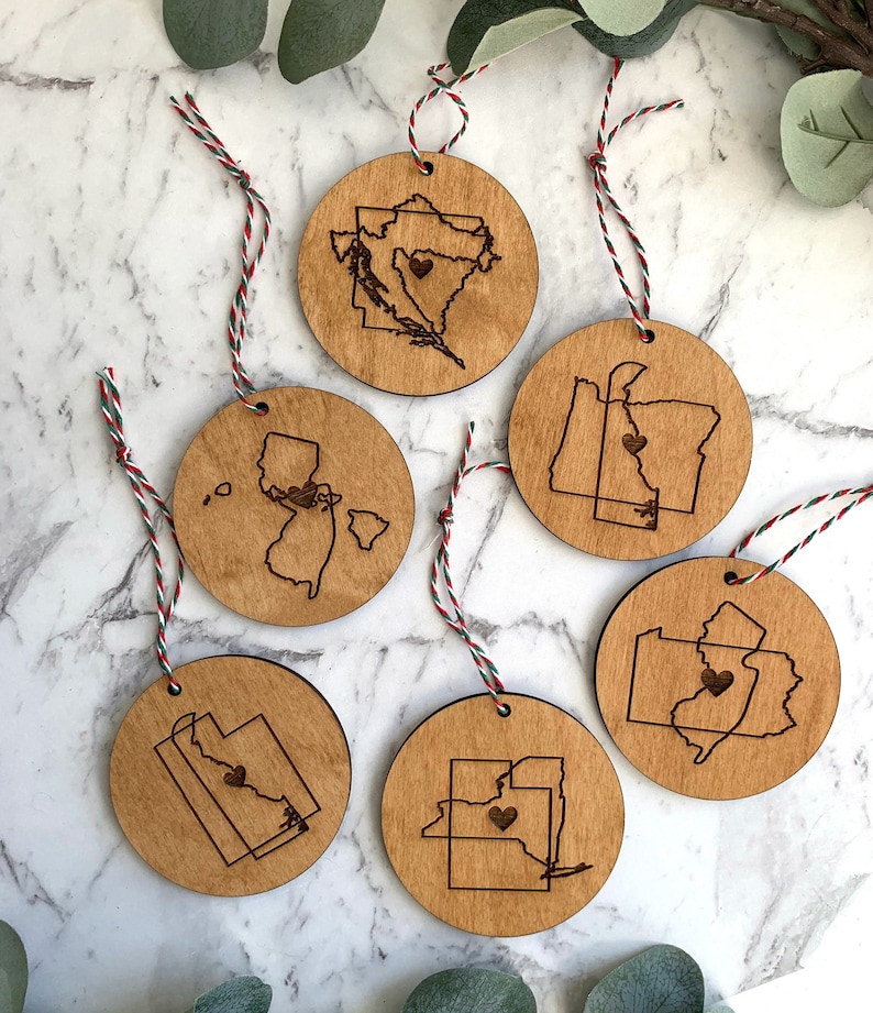 Puede incluir: Seis adornos de madera con un coraz&oacute;n en el centro de cada contorno de estado. Los estados son Oreg&oacute;n, Washington, Nueva Jersey, Utah, Idaho y Pensilvania.