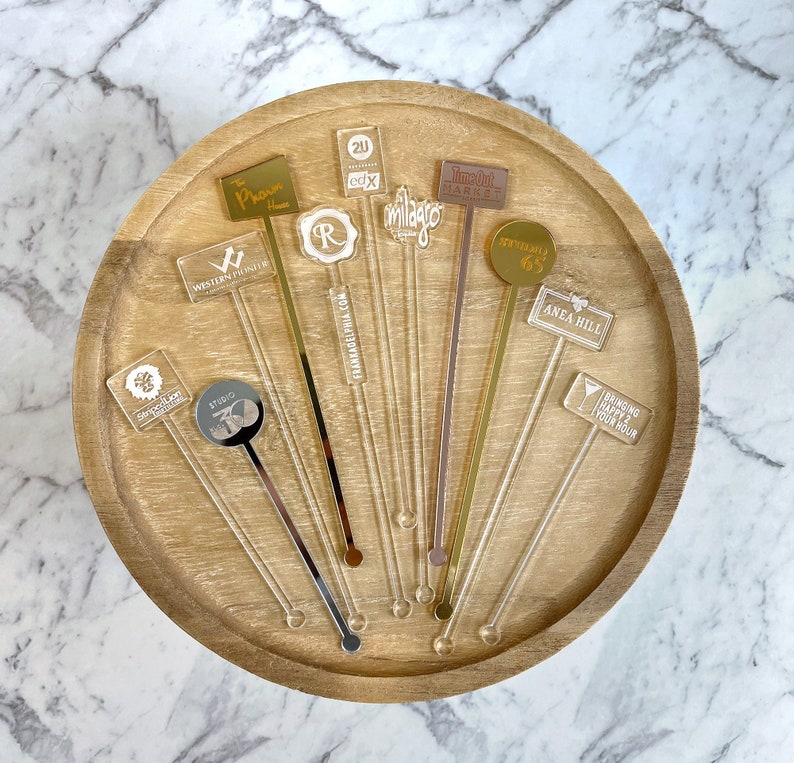 Bulk swizzle sticks featuring branded logos, arranged on a tray for a corporate appreciation night.