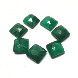 May include: Eight emerald green gemstone cabochons, each cut into a square shape with faceted edges. The stones are arranged in a circle on a white background.