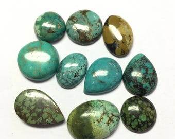 May include: A collection of turquoise gemstones in various shapes, including round, oval, and teardrop. The stones display a range of colors from bright teal to deep green, with brown and black matrix patterns. The polished surfaces reflect light, highlighting the natural variations.