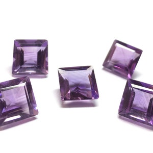 Puede incluir: Cinco piedras preciosas de amatista púrpura cortadas en forma cuadrada. Las piedras preciosas están facetadas y tienen un acabado brillante y pulido.