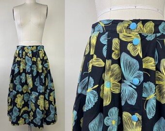 May include: A black midi skirt with a floral print featuring yellow and blue butterflies. The skirt has a button closure and a pleated design.
