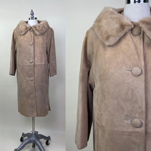 May include: A long, light brown suede coat with a large fur collar. The coat has a button closure and two pockets.