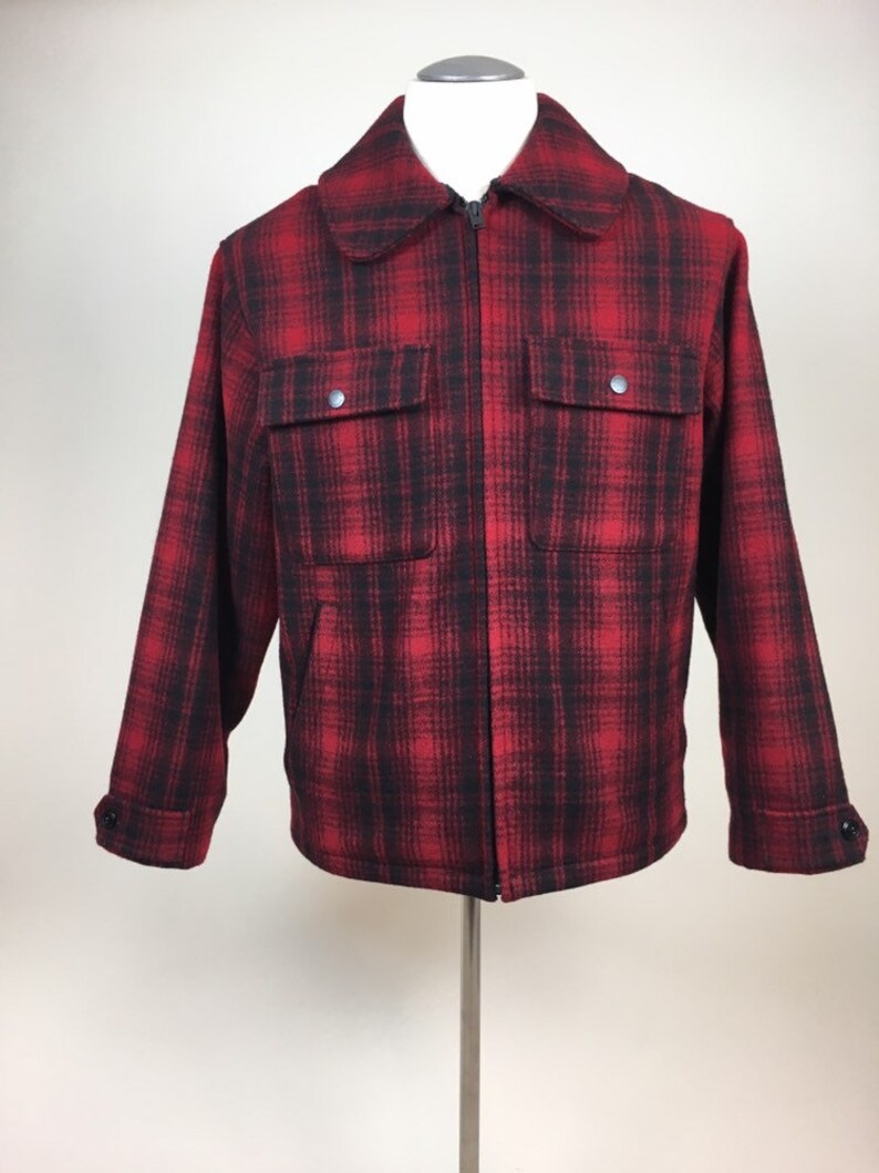 May include: A red and black plaid jacket with a full zipper closure, two front pockets, and buttoned cuffs. The jacket is displayed on a mannequin and has a classic, outdoorsy style.