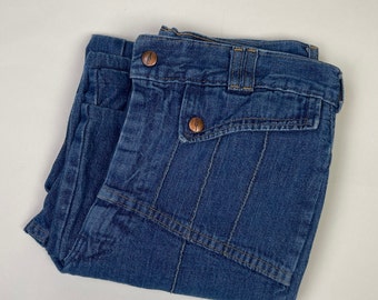 Può includere: Un paio di jeans blu in denim piegati a metà. I jeans hanno un design unico con più cuciture e tasche.