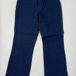 Puede incluir: Vaqueros de mezclilla azul oscuro con un dise&ntilde;o cl&aacute;sico de cinco bolsillos. Los vaqueros tienen un corte de pierna recta con una ligera abertura en la parte inferior. Los vaqueros est&aacute;n hechos de un material de mezclilla duradero.