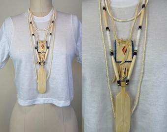 Collana vintage con sacchetto porta-medicinali in pelle di cervo e perline, osso intagliato e piuma
