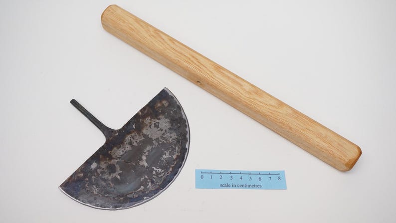 May include: A half-circle shaped metal tool with a wooden handle. The tool is used for cutting and shaping clay. The handle is about 30 cm long.