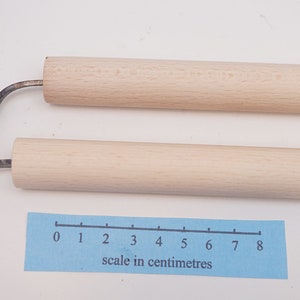 May include: Two wooden handled carving tools with metal blades. The blades are curved and have a hook shape. The tools are about 8 inches long. A ruler is included for scale, showing the tools are about 18 centimetres long.